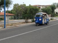 Tříkolek jezdí na Sardinii hodně, převažují nákladní. Tahle funguje jako minibus mezi Cala Gonone a pláží Cala Fuili. Slečna řidička byla usměvavá, přátelská, pokérovaná a hulila jako fabrický komín.